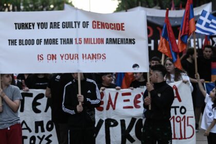 Members of the Armenian community hold flags and placards during a rally to commemorate the 109th anniversary of the Armenian genocide