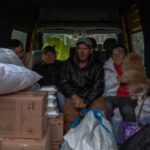 Evacuees from the village of Lyptsi, wait in a minivan at an evacuation point in Kharkiv as Russia presses its offensive