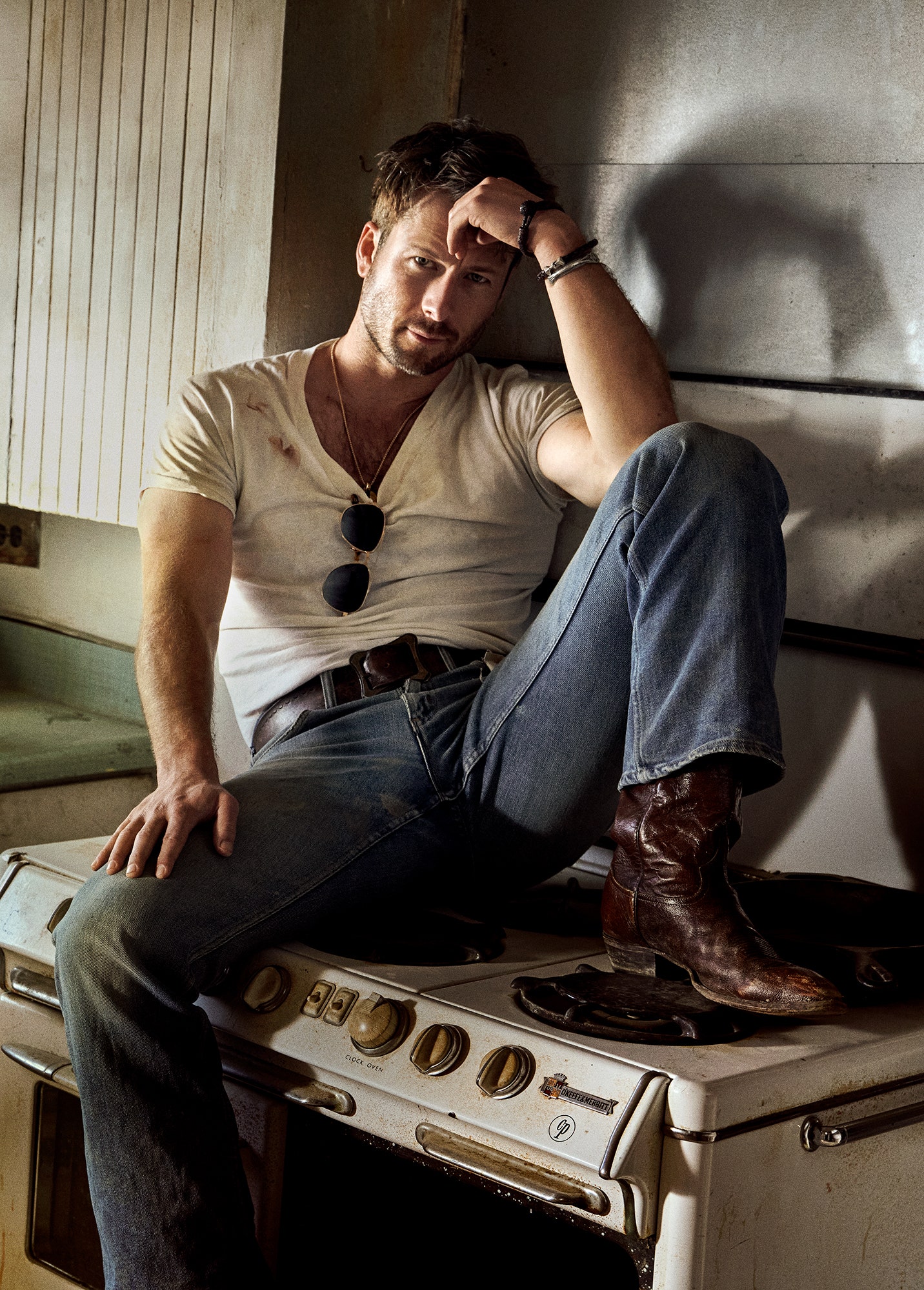 Glen Powell in vintage clothing belt and boots from Starday Vintage sunglasses by Moscot necklace and bracelet by David...