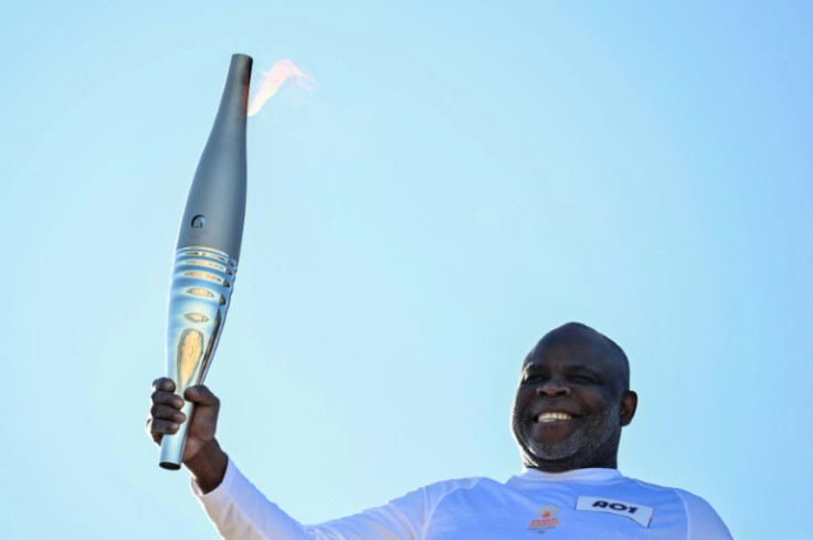 French football great Basile Boli was the first to take the Olympic torch in Marseille on Thursday