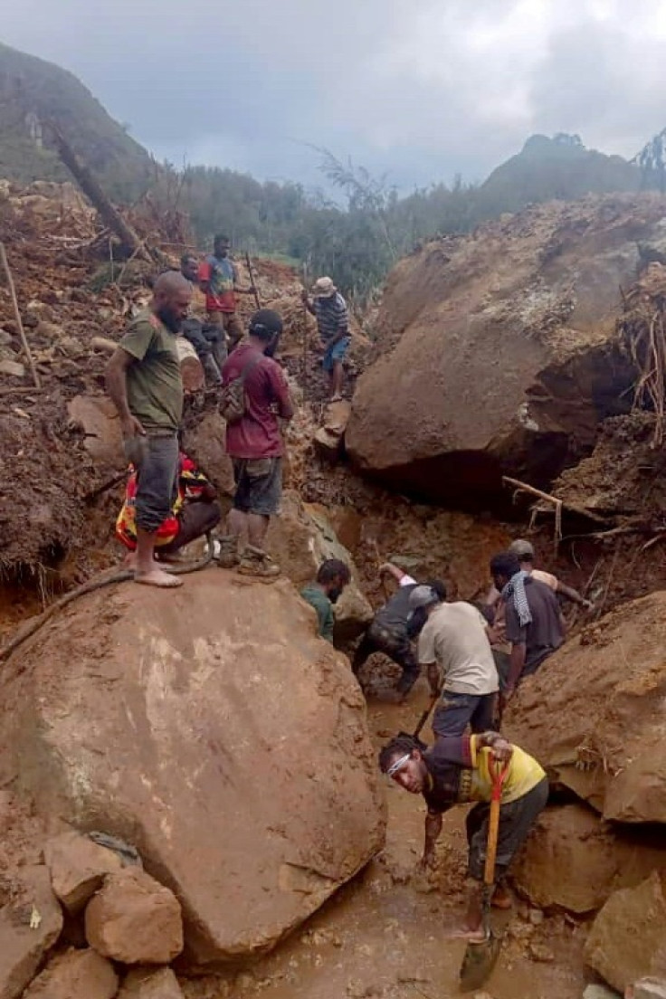 This handout photo taken and received on May 28, 2024 courtesy of local community leader Steven Kandai shows locals digging at the site of a landslide at Mulitaka village in the region of Maip Mulitaka, in Enga Province, Papua New Guinea.