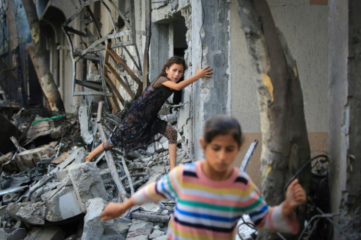 A Palestinian girl climbs over debris a day after an operation by the Israeli Special Forces in the Nuseirat camp, in the central Gaza Strip on June 9, 2024, amid the ongoing conflict between Israel and the Palestinian Hamas militant group.