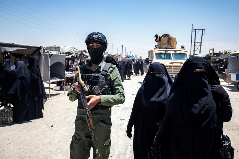 A Kurdish security forces member patrols the al-Hol camp in Syria where the families of IS fighters are held