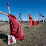 Red dresses on crosses are displayed at the entrance of a makeshift camp near near the Prairie Green landfill in Winnipeg, Manitoba, where the families of Indigenous women believed slaughtered by a serial killer are keeping vigil
