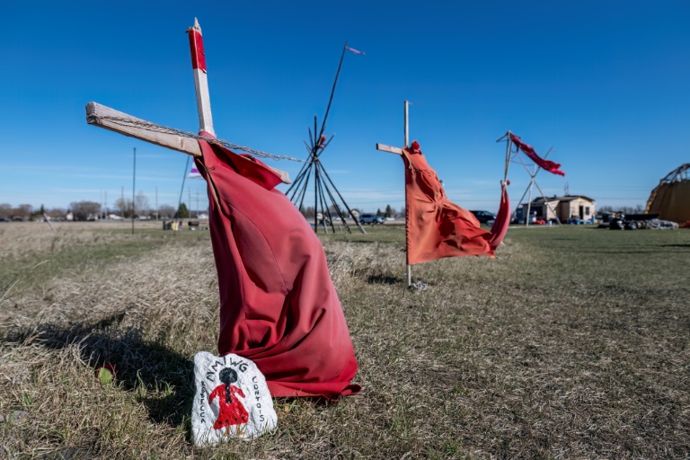Red dresses on crosses are displayed at the entrance of a makeshift camp near near the Prairie Green landfill in Winnipeg, Manitoba, where the families of Indigenous women believed slaughtered by a serial killer are keeping vigil
