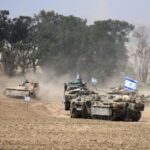 Israeli army vehicles drive near Israel's southern border with the Gaza Strip amid the ongoing conflict with the Palestinian militant group Hamas
