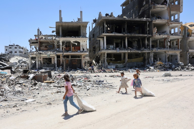 Palestinian children walk past destroyed buildings in the Jabalia refugee camp in northern Gaza