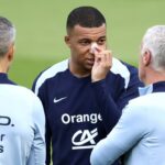 Kylian Mbappe, with a plaster on his broken nose, speaks to France coach Didier Deschamps at the team's Euro 2024 base in Paderborn on Wednesday