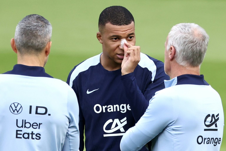 Kylian Mbappe, with a plaster on his broken nose, speaks to France coach Didier Deschamps at the team's Euro 2024 base in Paderborn on Wednesday