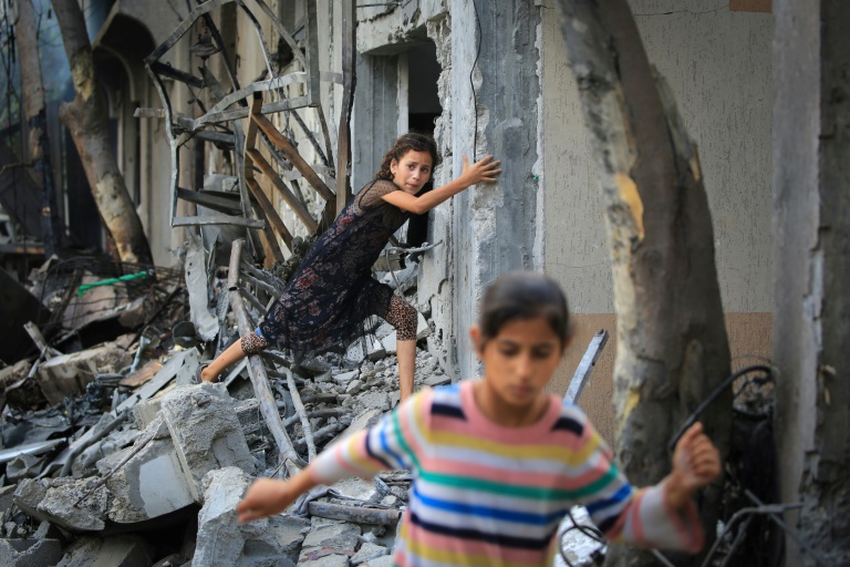 A Palestinian girl climbs over debris a day after an operation by the Israeli Special Forces in the Nuseirat camp, in the central Gaza Strip on June 9, 2024, amid the ongoing conflict between Israel and the Palestinian Hamas militant group.