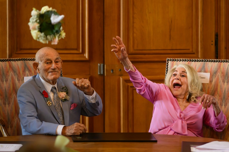 Jeanne Swerlin, 96, throws her bouquet of flowers after officialising her marriage to US WWII veteran Harold Terens, 100, in the town hall of Carentan-les-Marais, in Normandy
