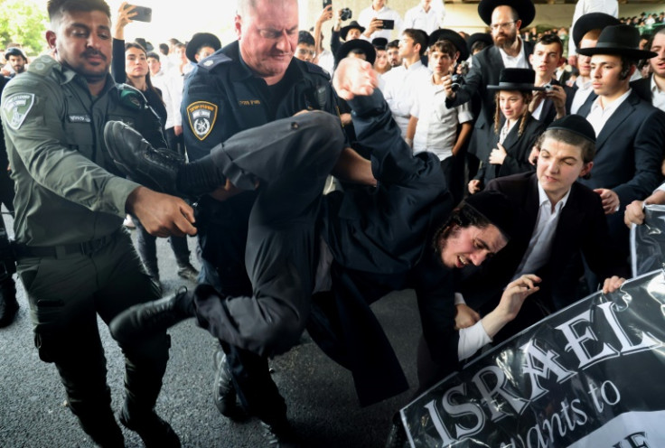 Israeli police remove a protester during a demonstration against the military draft