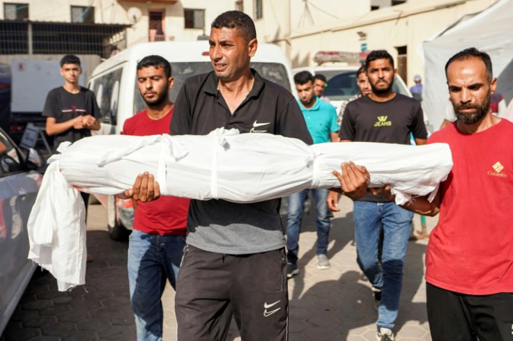 A man carries the body of Abdelrahman Yussef Abu Galambo, 11, who died during Israeli bombardment in Bureij refugee camp, central Gaza