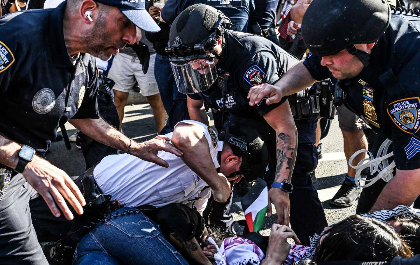 A police commander punches a protester in Brooklyn on May 31 during a demonstration against Israeli attacks on Rafah. A New York court approved a settlement agreement that obligates the NYPD to minimize its presence at protests and facilitate First Amendment activity.