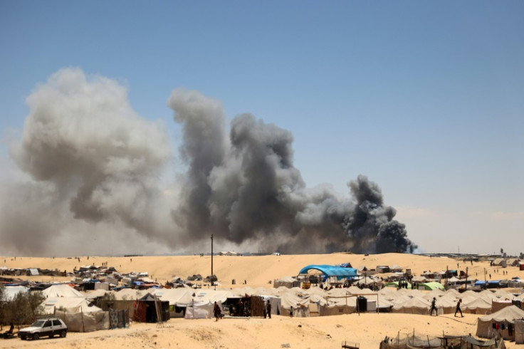 Smoke rises near a makeshift camp for displaced Palestinians in the area of Tel al-Sultan in Rafah in the southern Gaza Strip on May 30, 2024