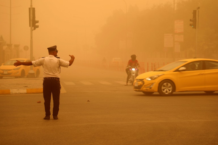 A traffic policeman directs traffic flow in Nasiriyah during a heavy dust storm