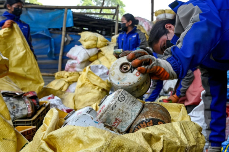 Worker segregate waste materials retrieved from Mount Everest for recycling