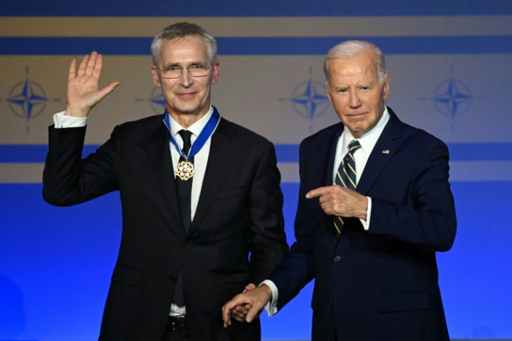 US President Joe Biden  gestures toward NATO Secretary-General Jens Stoltenberg after giving him the Presidential Medal of Freedom