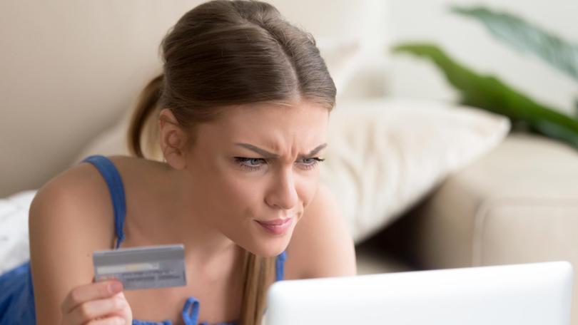 Confused woman having problem with credit card making online payment