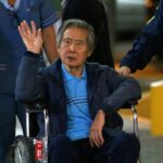 Peru's former President Alberto Fujimori waves to supporters as he is wheeled out of the Centenario Clinic in Lima on January 4, 2018