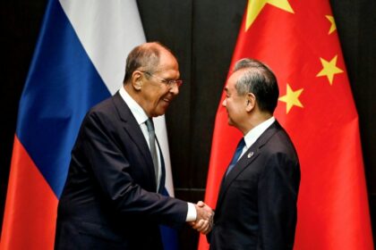Russia's Foreign Minister Sergei Lavrov (left) shakes hands with his Chinese counteropart Wang Yi on the sidelines of the ASEAN meeting in Vientiane