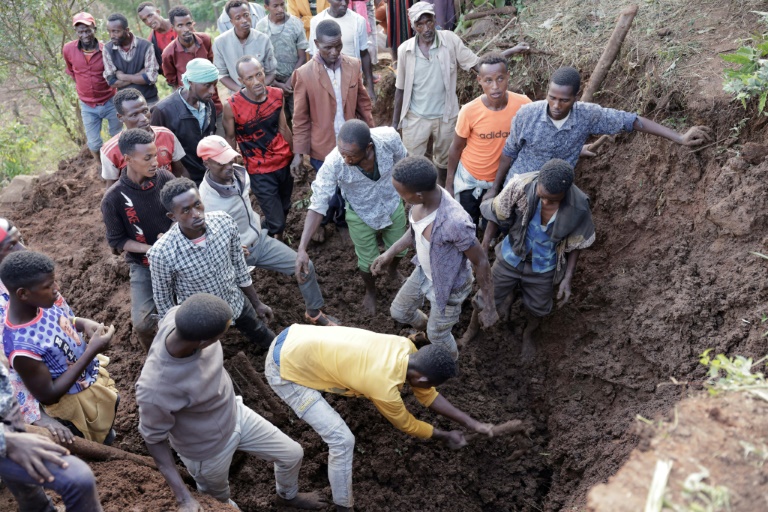 Residents and volunteers dig through mud in the search for survivors