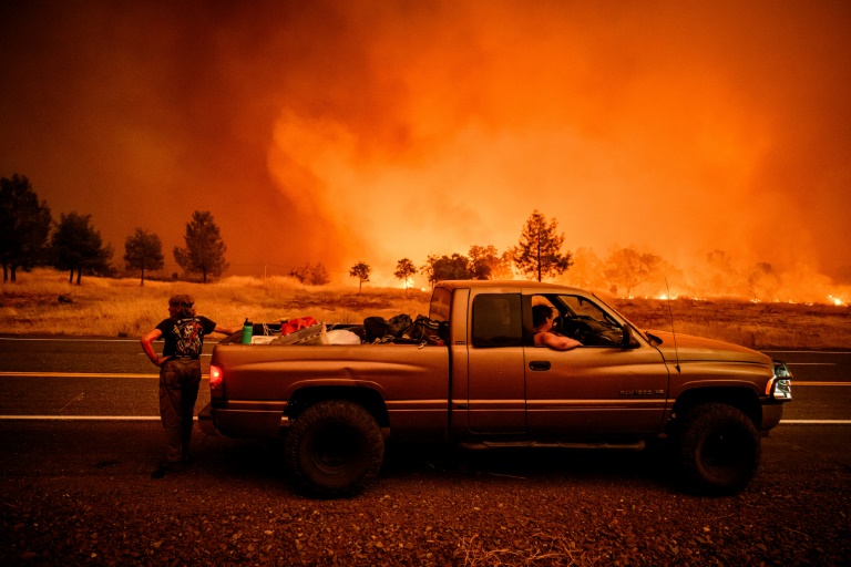 Surrounded by flames, residents pull over on the side of the road while evacuating due to the Park Fire on July 26, 2024