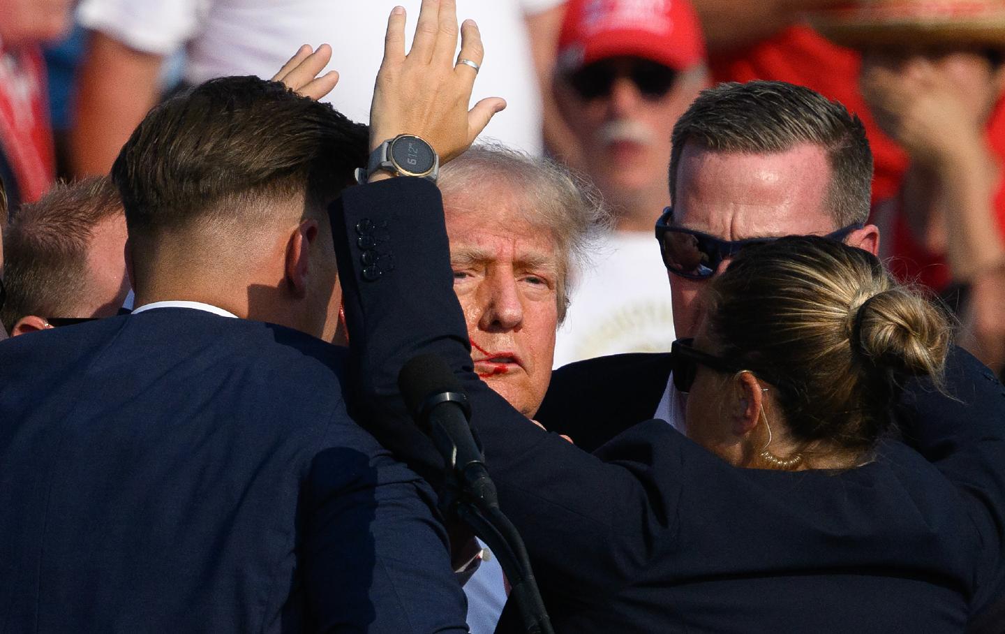 Secret Service agents surround Republican presidential candidate former President Donald Trump onstage after he was injured at a rally on July 13, 2024, in Butler, Pennsylvania.