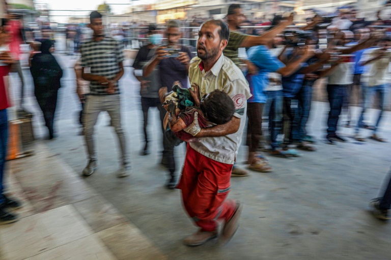 A paramedic carries a child wounded during Israeli bombardment to the emergency ward of the Nassr hospital in Khan Yunis in the southern Gaza Strip on July 9, 2024