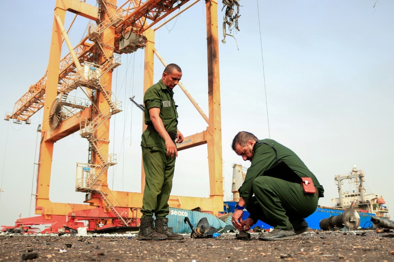 Members of security forces inspect debris on the dock a day after Israeli strikes on Yemen's rebel-held Hodeida port