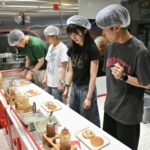 Visitors role play as researchers in a mock burger laboratory at an adults-only event at KidZania in Seoul