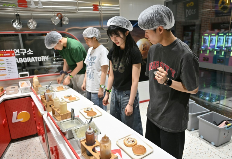 Visitors role play as researchers in a mock burger laboratory at an adults-only event at KidZania in Seoul