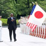 US Secretary of Defense Lloyd Austin (C) and his Japanese counterpart Minoru Kihara (L) review an honour guard prior to a meeting in Tokyo Sunday
