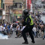 A riot police officer uses tear gas against demonstrators during a protest by opponents of Venezuelan President Nicolas Maduro's government in the Catia neighborhood of Caracas on July 29, 2024