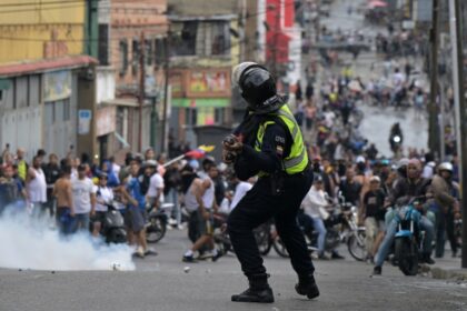 A riot police officer uses tear gas against demonstrators during a protest by opponents of Venezuelan President Nicolas Maduro's government in the Catia neighborhood of Caracas on July 29, 2024