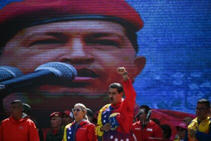 Nicolas Maduro was thrust into power as the handpicked successor of Hugo Chavez (on screen) who died of cancer in 2013 but is still hailed as a revolutionary hero by many