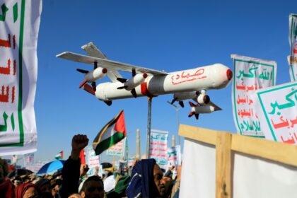A demonstrator carries a mock drone during a rally in the Huthi-run Yemeni capital Sanaa on February 23, 2024