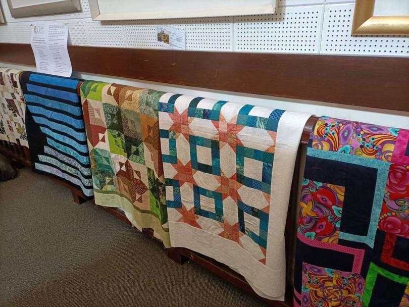Some of the quilts for comfort the CWA and Craft Group ladies had sewn on display.