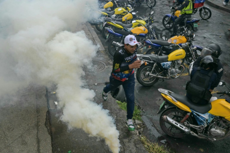 A demonstrator runs away from teargas during a protest against Venezuelan President Nicolas Maduro after he claimed victory in Sunday's election