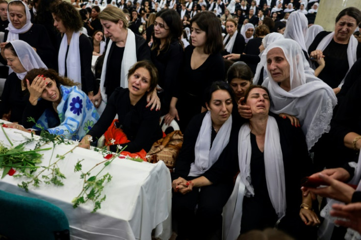Druze women mourn by a coffin during a funeral after a rocket strike from Lebanon which, Israel's military said, killed 12 young people