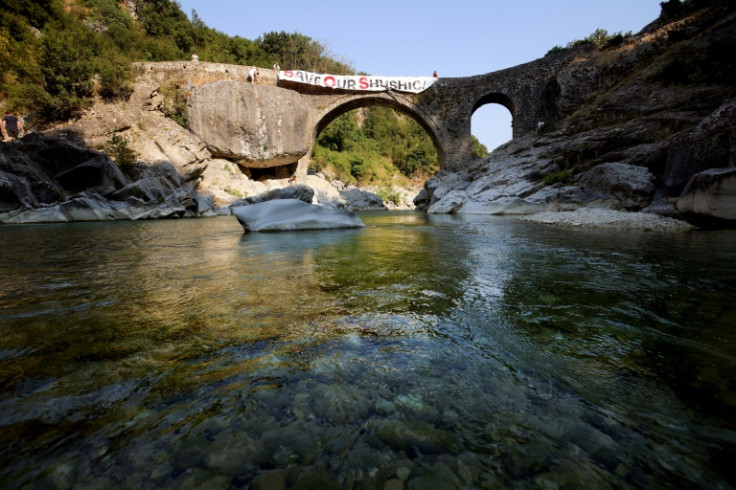With emerald water flowing underneath a 14th-century stone bridge, the Shushica River in southern Albania cuts a picturesque image that activists say is now at risk, due to a project seeking to divert the tributary