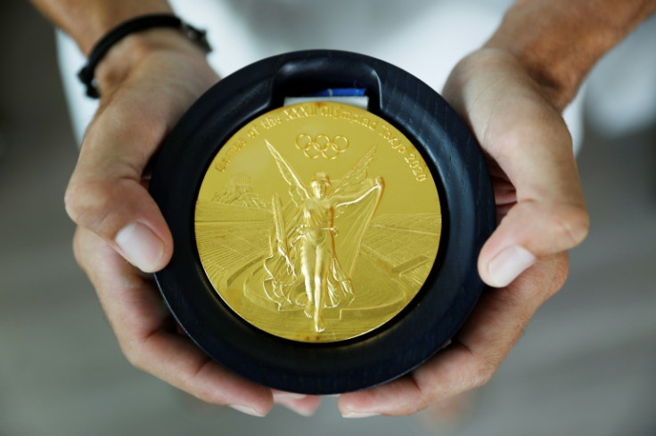 Fernando Dayan Jorge Enriquez holds the gold medal he won at the 2020 Olympic Games in Tokyo, inside his apartment in Cape Coral, Florida