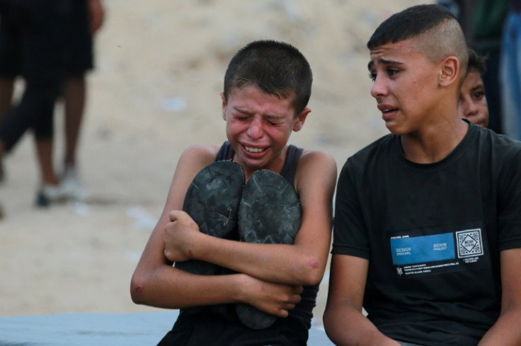 A Palestinian boy cries as killed Gazans are brought for burial outside Nasser hospital in Gaza's Khan Yunis following Israeli bombardment east of the city