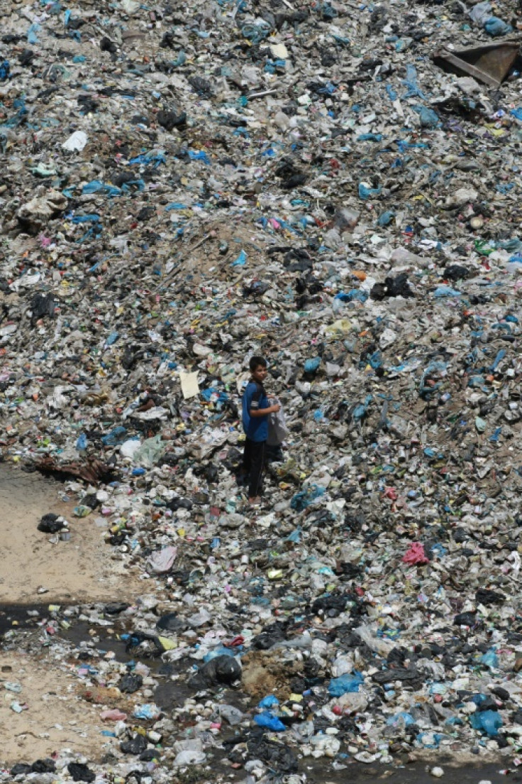 A Palestinian boy walks through heaps of garbage at a camp for displaced people in Khan Yunis, southern Gaza -- many are living in unsanitary conditions