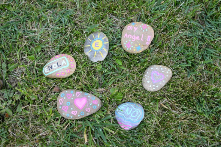 Pebbles painted by parents, some with the names of the children they have lost