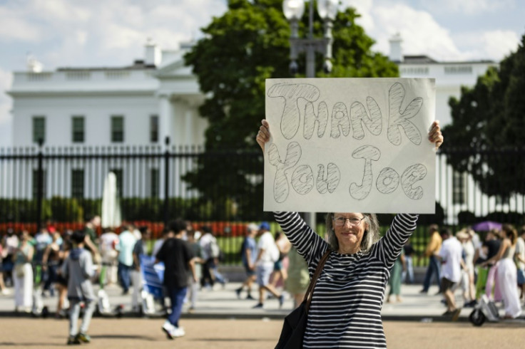 A woman holds a sign reading 'Thank you Joe' outside the White House after US President Joe Biden announced he will not seek reelection