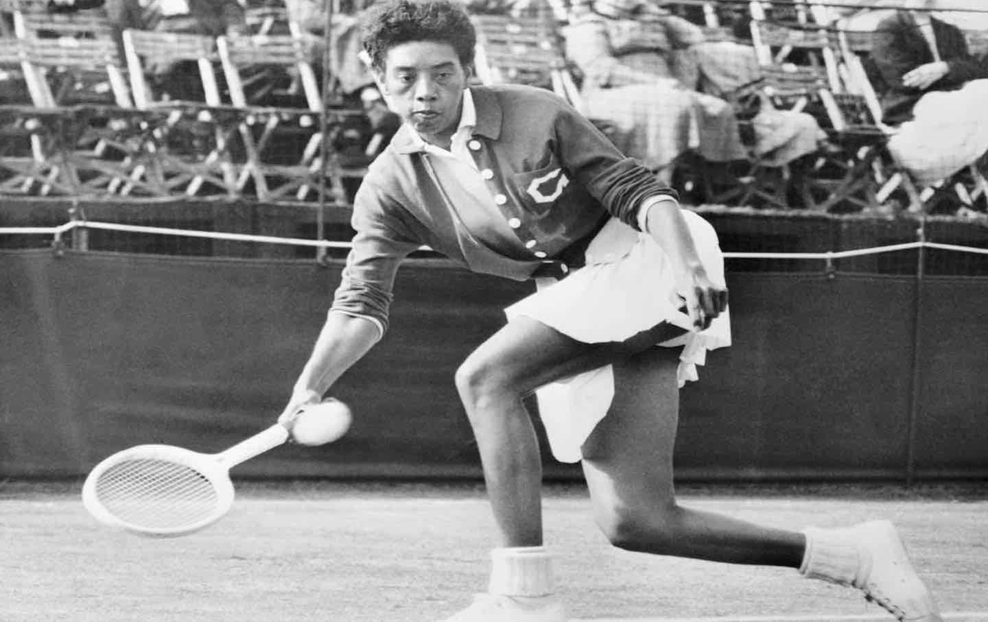 American tennis star Althea Gibson hits a return shot to Colette Monnot during her singles match at the Surrey Grass Court Championship, held at the Surbiton Racket and Fitness Club.