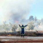 A firefighter coordinates the fight against a wildfire that has forced the evacuation of thousands of people around Athens