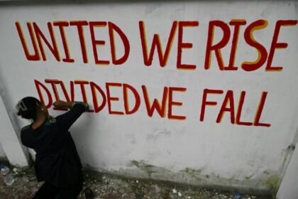 A student creates a wall painting along a road in Dhaka: the interim administration faces a monumental challenge of ending disorder and enacting democratic reforms