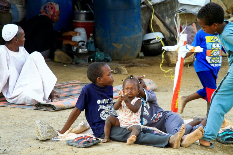 People rest at a makeshift camp after being evacuated due to deadly floods in eastern Sudan